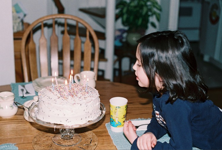 Blowing out the candles, age 8.